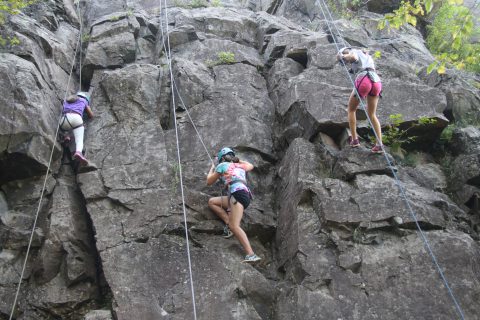 Camp Thunderbird kids climbing a rock face during adventure camp