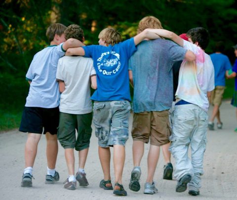 Boys walking together with arms around each other's shoulders