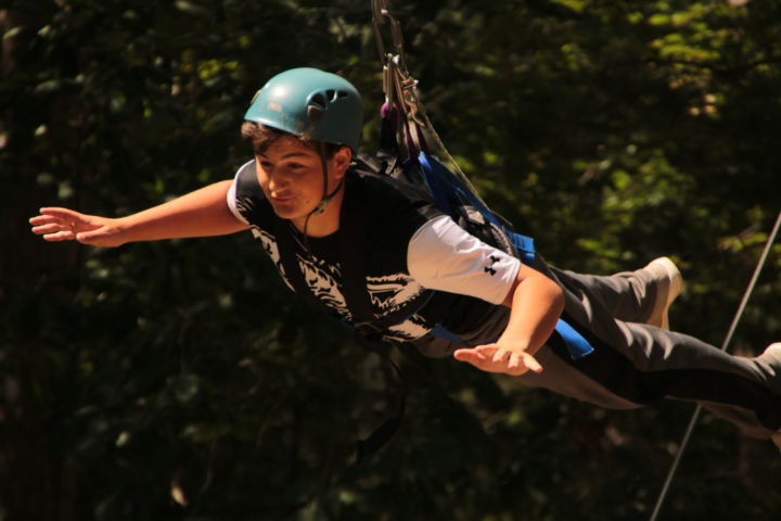 Boy doing a high ropes course at camp
