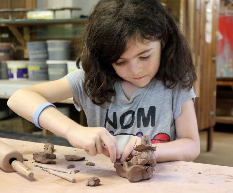 Girl making pottery at Camp Thunderbird