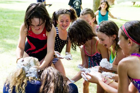 Girls having fun with a shaving cream activity at camp