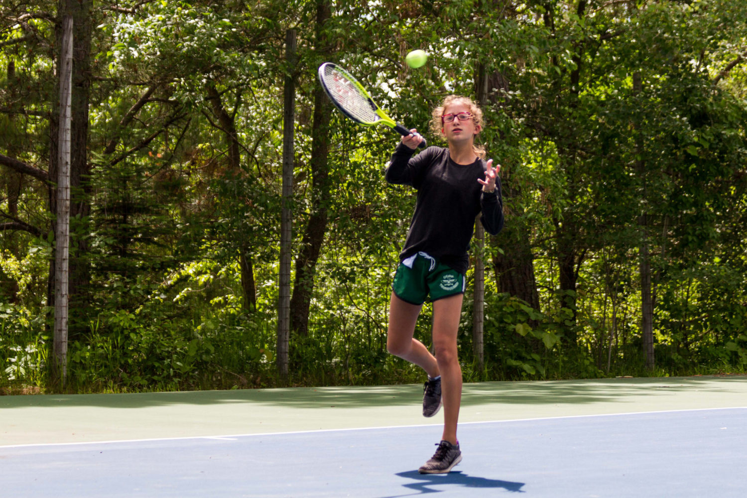 Girl hitting tennis ball