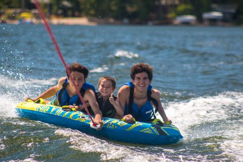 Kids water skiing behind a boat on a lake